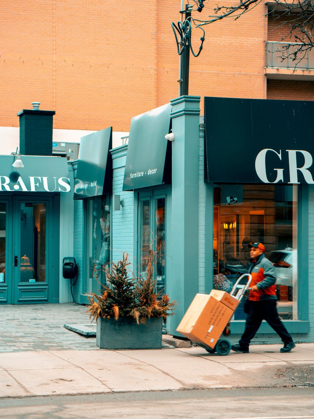 man-pushing-hand-truck-beside-building-2047397
